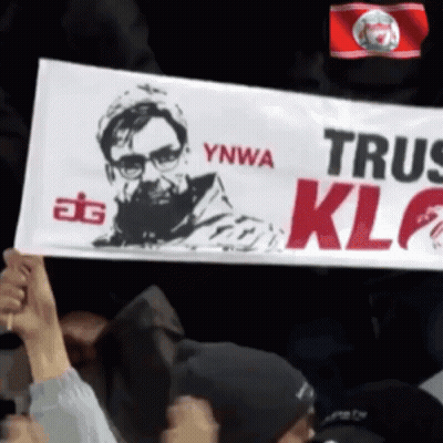a man holds up a sign that says ynwa trus klf