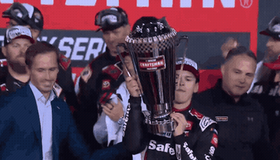 A Man Holds Up A Trophy That Says Safe On It GIF