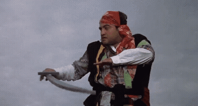 A Man In A Bandana Is Holding A Rope And Pointing At Something . GIF