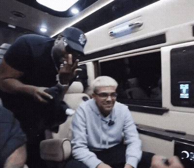 A Man In A Baseball Cap Is Talking To Another Man In A Car GIF