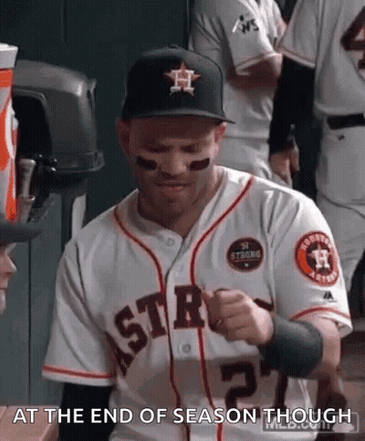 A Man In A Baseball Uniform Is Sitting In A Dugout . GIF