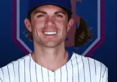 A Man In A Baseball Uniform Is Smiling In Front Of A Blue And Purple Background GIF