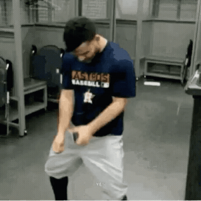 A Man In A Baseball Uniform Is Standing In A Locker Room With His Hands On His Hips . GIF