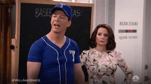 A Man In A Baseball Uniform Stands Next To A Woman In A Floral Dress GIF