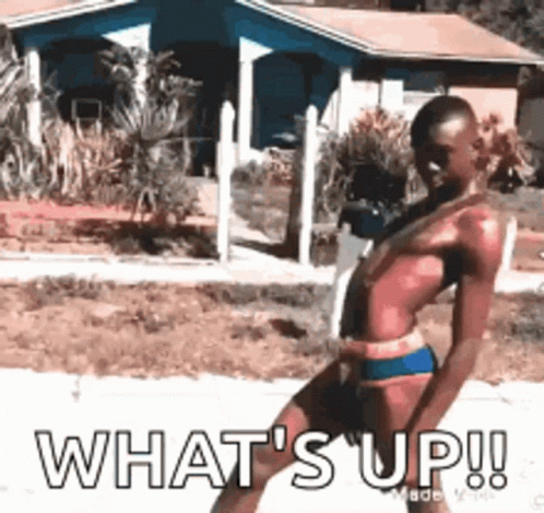 A Man In A Bathing Suit Is Standing In Front Of A House With The Words What 'S Up ! GIF