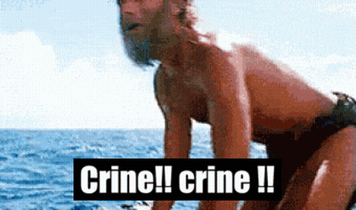 A Man In A Bathing Suit Is Standing In The Ocean With The Words Crine !! Crine !! Behind Him GIF