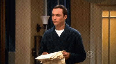 A Man In A Bathrobe Holds A Stack Of Papers GIF