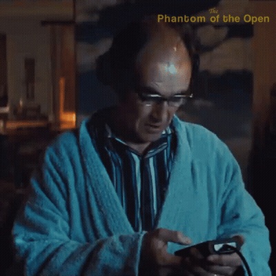 A Man In A Bathrobe Is Playing A Video Game With The Phantom Of The Open Written In The Corner GIF
