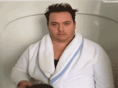 A Man In A Bathrobe Is Sitting In A Bathtub With The Hashtag Trendizisst GIF
