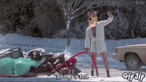 A Man In A Bathrobe Is Standing In The Snow And Says " Shitter 'S Full " GIF
