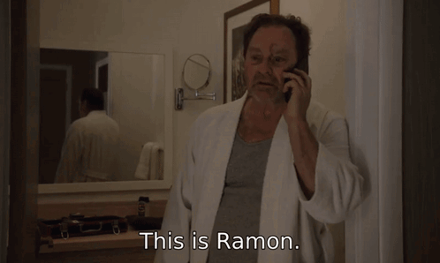 A Man In A Bathrobe Is Talking On A Cell Phone With The Words This Is Ramon Below Him GIF
