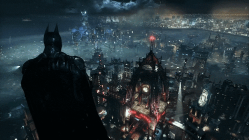A Man In A Batman Costume Stands In Front Of A City GIF