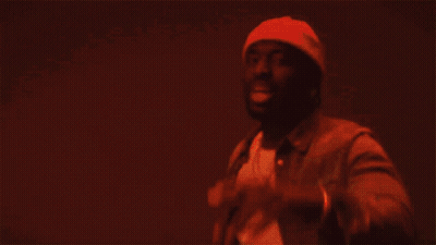A Man In A Beanie And Leather Jacket Is Dancing GIF