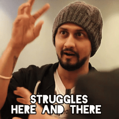 A Man In A Beanie Says " Struggles Here And There " With His Hand GIF