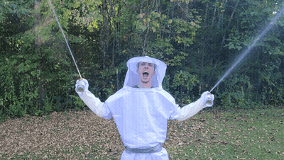 A Man In A Beekeeper Costume Is Holding Two Swords GIF