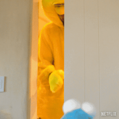 A Man In A Big Bird Costume Is Standing Next To A Netflix Sign GIF