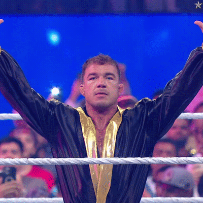 A Man In A Black And Gold Robe Stands In A Boxing Ring GIF
