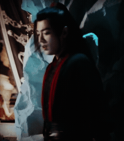 A Man In A Black And Red Costume Is Standing In The Dark GIF