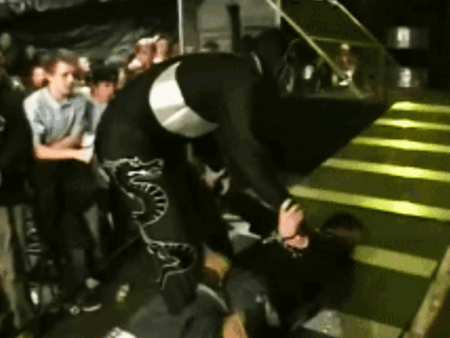 A Man In A Black And Silver Outfit With Snake Print On The Pants GIF