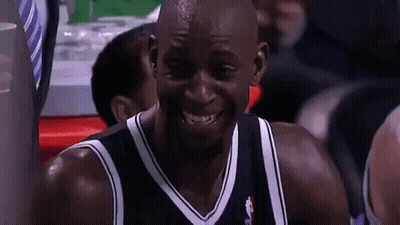 A Man In A Black And White Jersey Is Smiling GIF