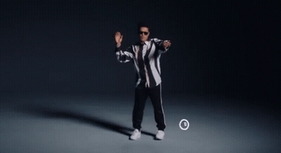 A Man In A Black And White Striped Jacket Is Dancing In Front Of A Circle With The Letter D On It GIF