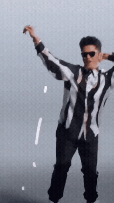 A Man In A Black And White Striped Shirt Is Dancing GIF