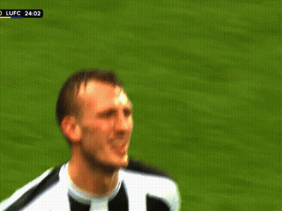 A Man In A Black And White Striped Shirt Is Making A Funny Face On A Soccer Field GIF