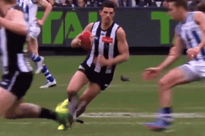 A Man In A Black And White Striped Shirt Is Running With A Red Ball GIF