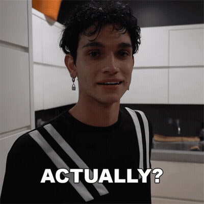 A Man In A Black And White Striped Shirt Is Smiling And Says Actually GIF