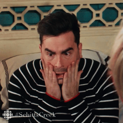 A Man In A Black And White Striped Sweater With #Schitts Creek On The Bottom Right GIF