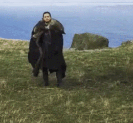 A Man In A Black Cape Is Walking In A Field GIF