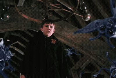 A Man In A Black Cloak Is Standing In Front Of A Ceiling With A Bunch Of Purple Monsters Flying Around . GIF