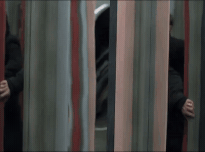 A Man In A Black Coat Is Running Through A Mirrored Room GIF