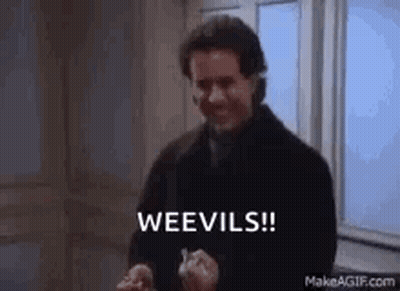 A Man In A Black Coat Is Standing In Front Of A Window Holding A Knife And Saying Weevils ! GIF