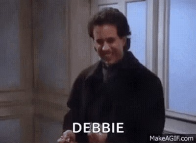 A Man In A Black Coat Is Standing In Front Of A Window With The Word Debbie Written On His Face . GIF