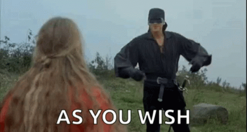 A Man In A Black Costume Is Standing Next To A Woman In A Field . GIF