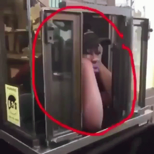A Man In A Black Hat Is Standing In A Booth With A Sign That Says 031 GIF