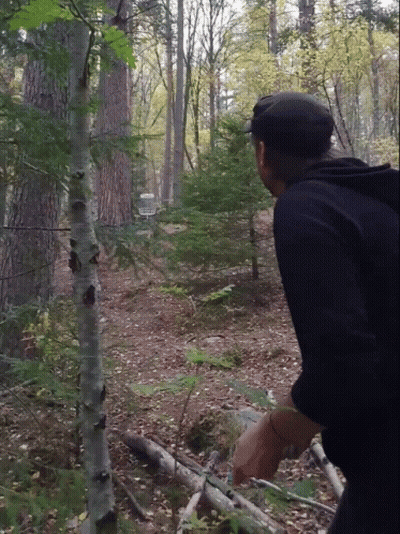 A Man In A Black Hat Stands In The Woods GIF