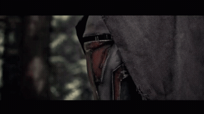 A Man In A Black Hood Is Holding A Red Light Saber In A Dark Forest GIF