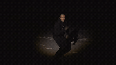A Man In A Black Hoodie Holds A Piece Of Red Paper With The Number 2123 On It GIF