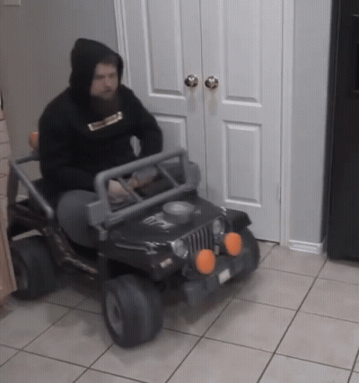 A Man In A Black Hoodie Is Driving A Black Jeep GIF