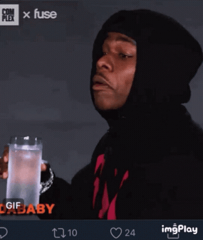 A Man In A Black Hoodie Is Holding A Glass Of Water In His Hand GIF