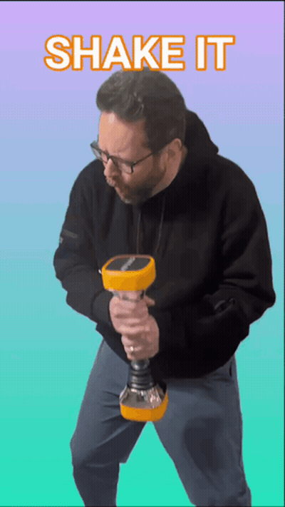 A Man In A Black Hoodie Is Holding A Yellow Object And The Words Shake It Are Above Him GIF