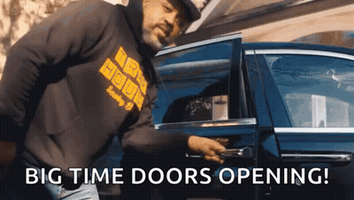 A Man In A Black Hoodie Is Opening The Door Of A Car GIF