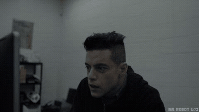 A Man In A Black Hoodie Is Sitting In Front Of A Computer Screen . GIF
