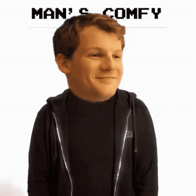 A Man In A Black Hoodie Is Smiling With The Words Man 'S Comfy Below Him GIF