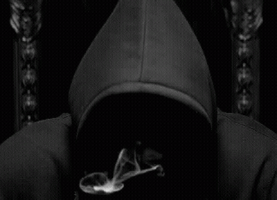 A Man In A Black Hoodie Is Smoking A Cigarette In A Black And White Photo . GIF