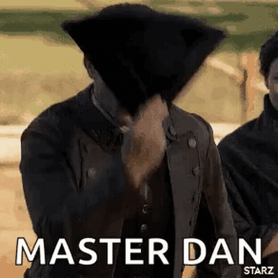 A Man In A Black Jacket Is Covering His Face With A Black Hat And Says `` Master Dan '' . GIF