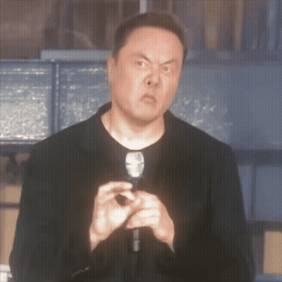A Man In A Black Jacket Is Holding A Microphone And Making A Face GIF
