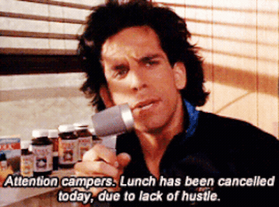 A Man In A Black Jacket Is Holding A Microphone And Says Attention Campers GIF